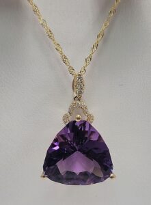 14k Yellow Gold Amethyst and Diamond Pendant.  Pendant contain a 15mm Fantasy cut trillion Amethyst with 14 diamonds totaling .10ct.  